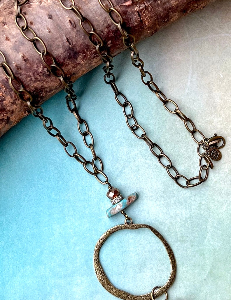 Long necklace with circle pendant with stone detail 