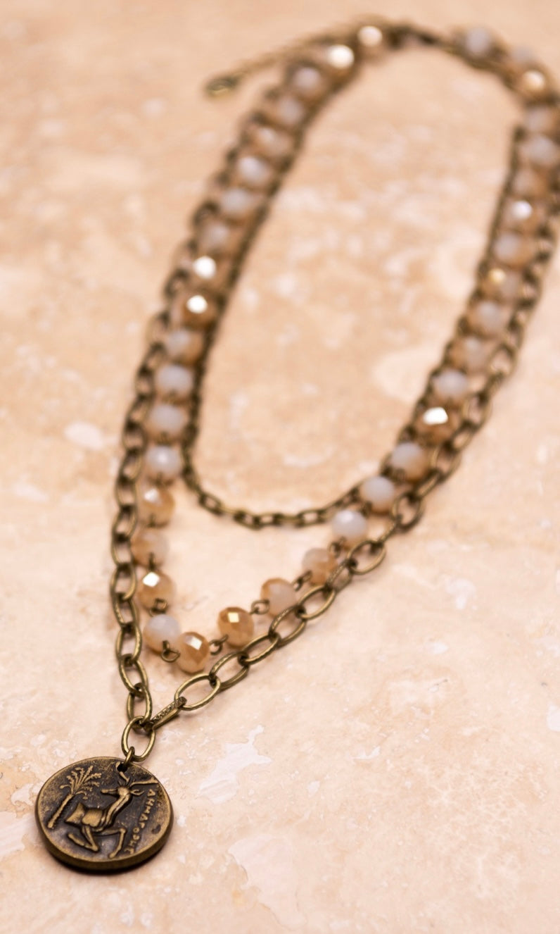 chain and beaded 3 chain necklace with a brass pendant 