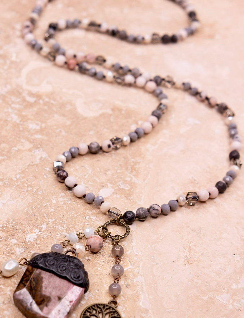 Beaded necklace with stone pendant in a light mauve color