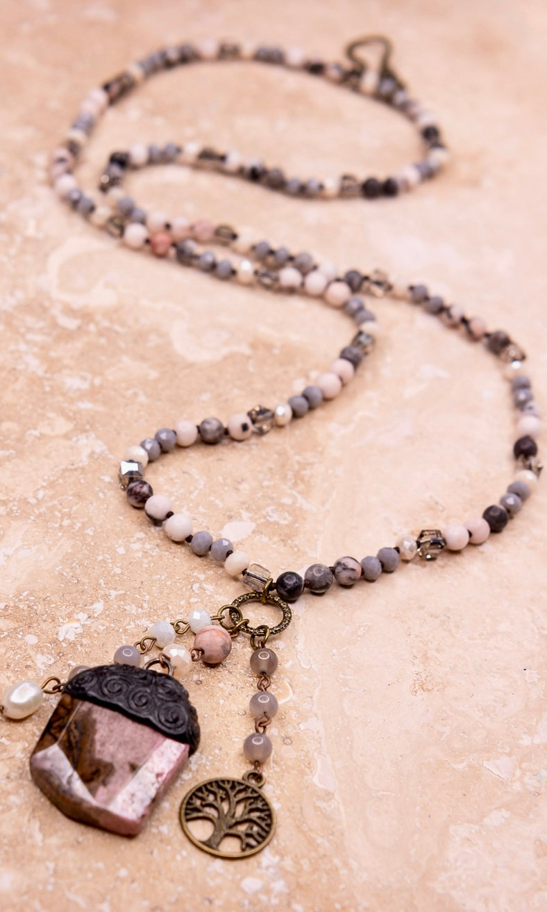 Beaded necklace with stone pendant in a light mauve color