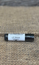 Lip balm tube labeled 'Ewe Creek Farm Co.' on a textured surface