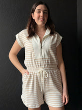 Woman wearing a striped romper against a black background