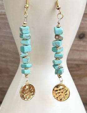 Turquoise beaded earrings with gold accents on a white mannequin bust.