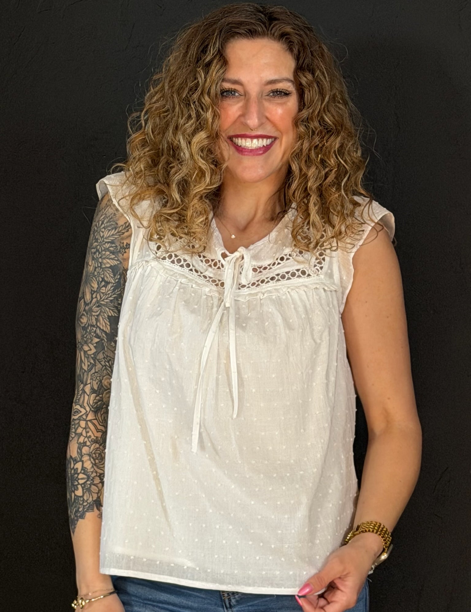 Woman wearing a white lace top against a black background