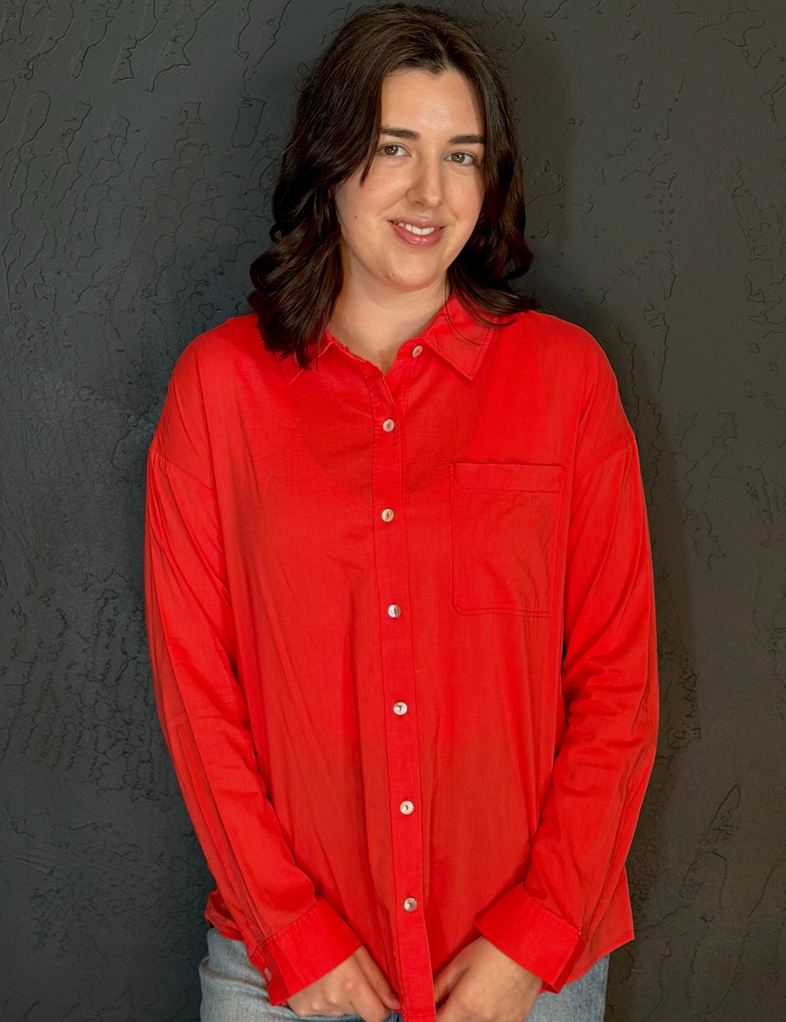 Person wearing a red shirt against a dark background