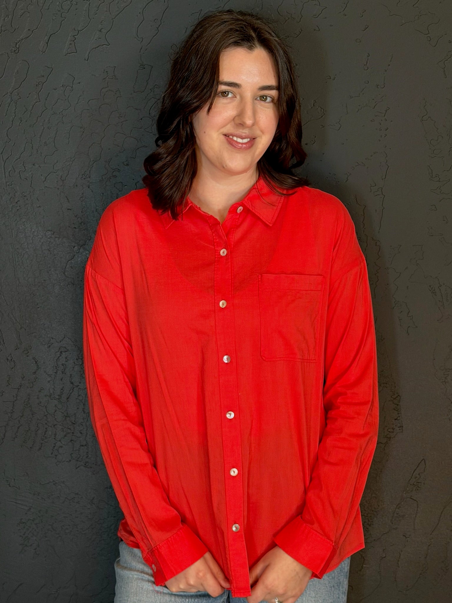 Person wearing a red shirt against a dark background