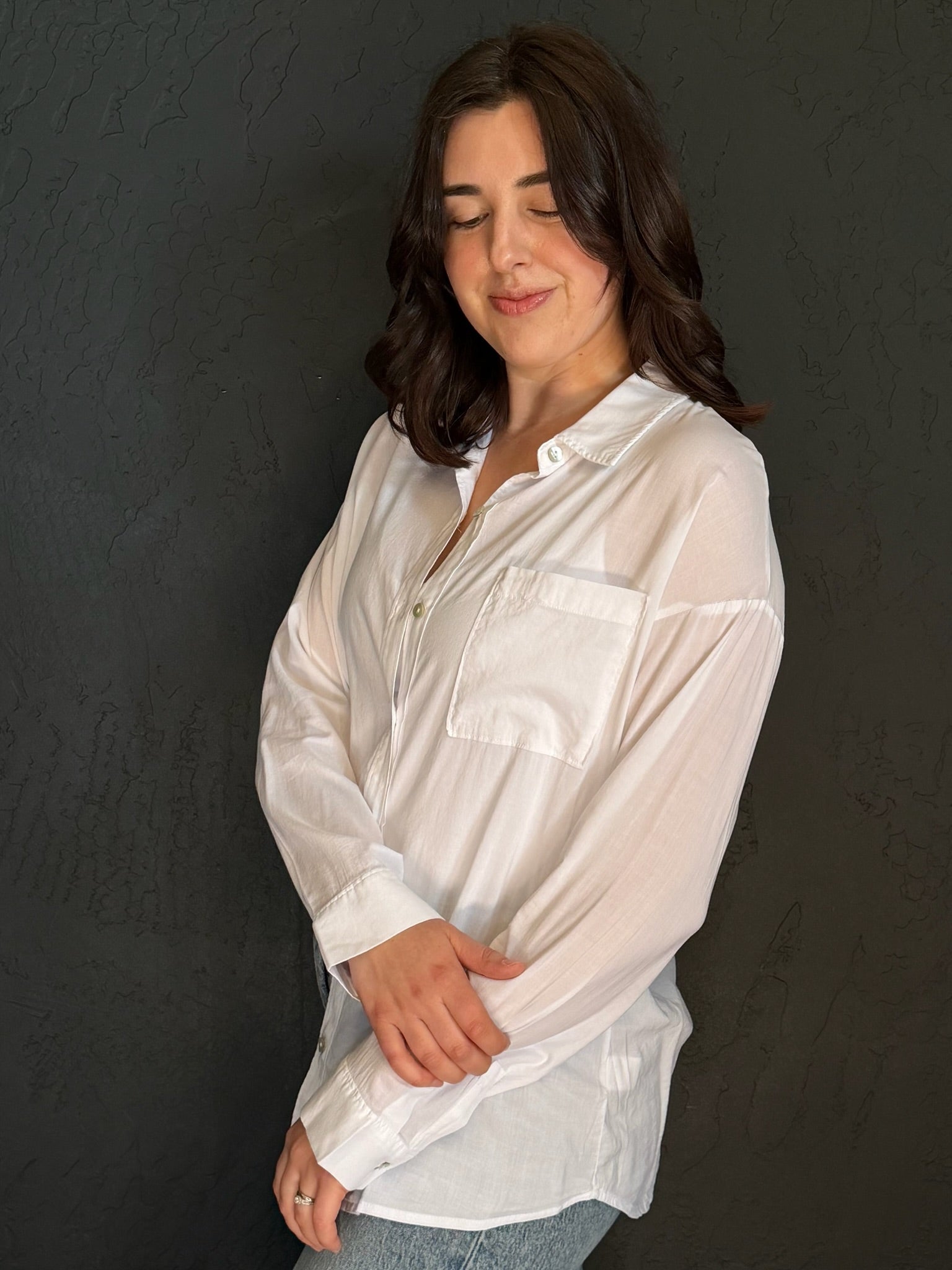 Woman wearing a white blouse against a dark background