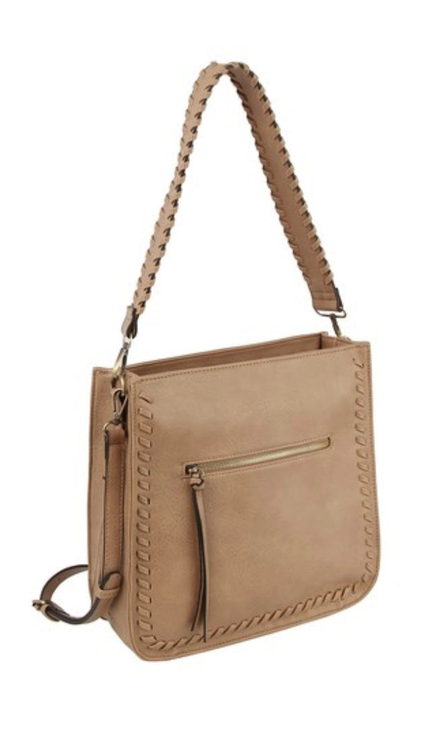 A mocha-colored whipstitch shoulder bag with a braided handle and an exterior zip pocket, displayed against a plain background.