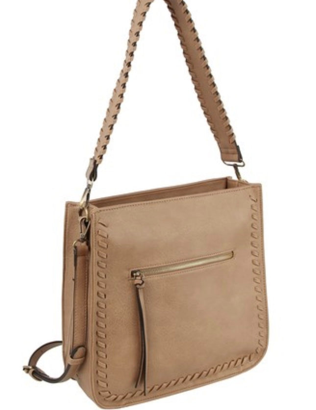 A mocha-colored whipstitch shoulder bag with a braided handle and an exterior zip pocket, displayed against a plain background.