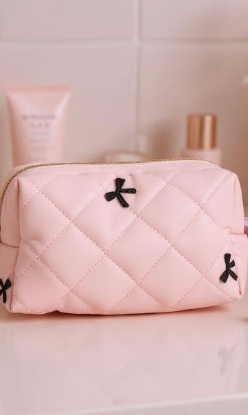 Pink quilted pouch with black accents on a light pink background