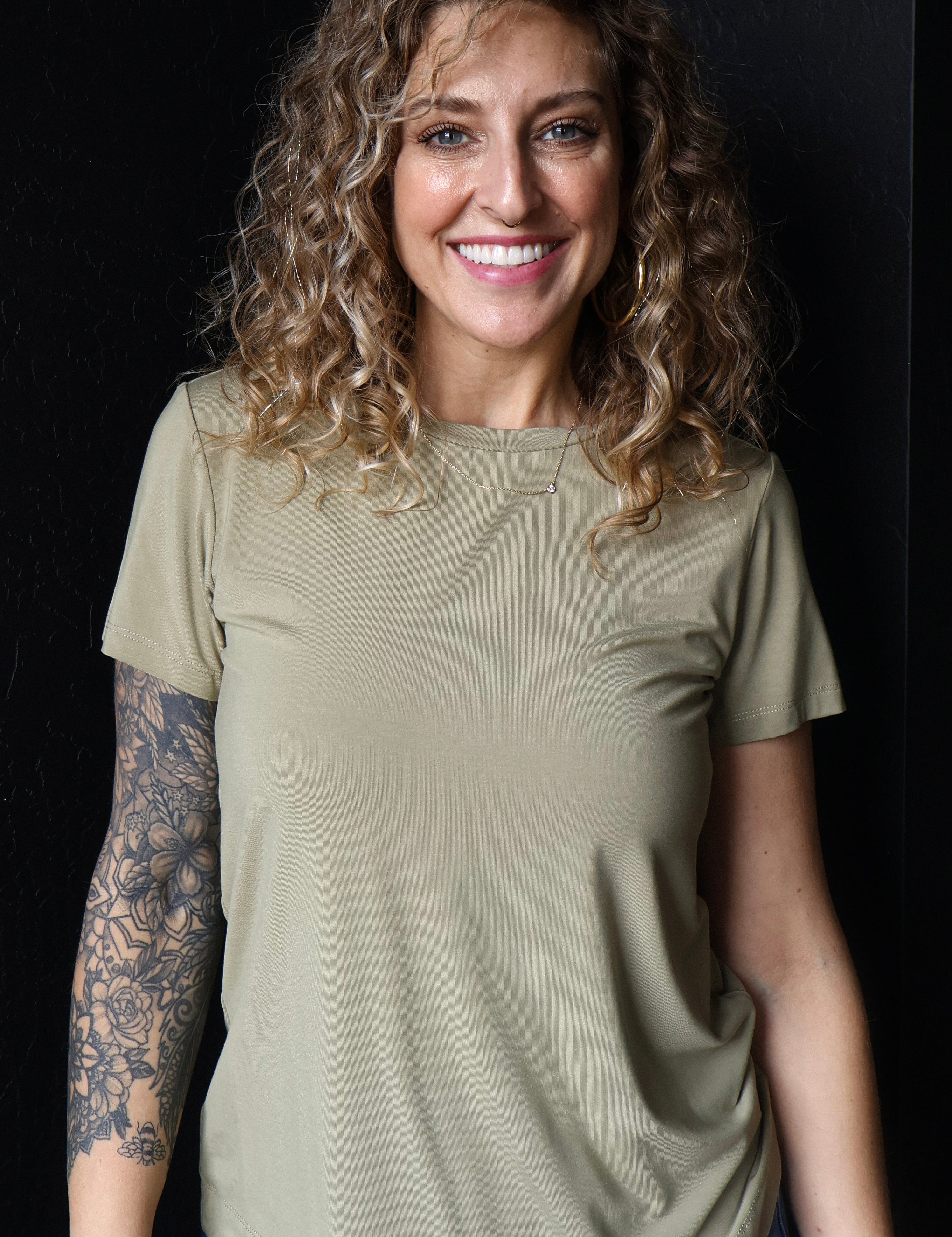 Woman wearing a green t-shirt against a black background
