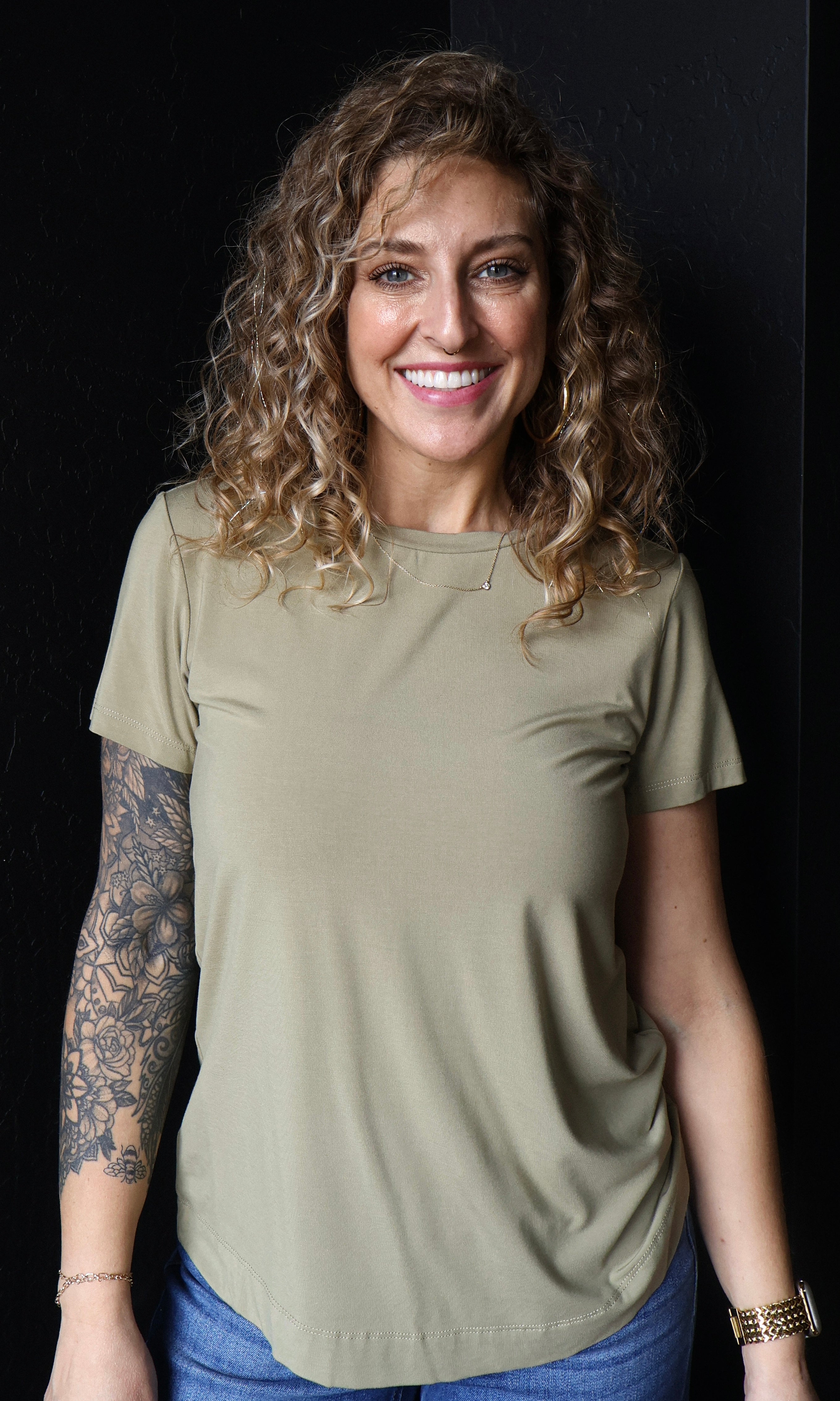 Woman wearing a green t-shirt against a black background