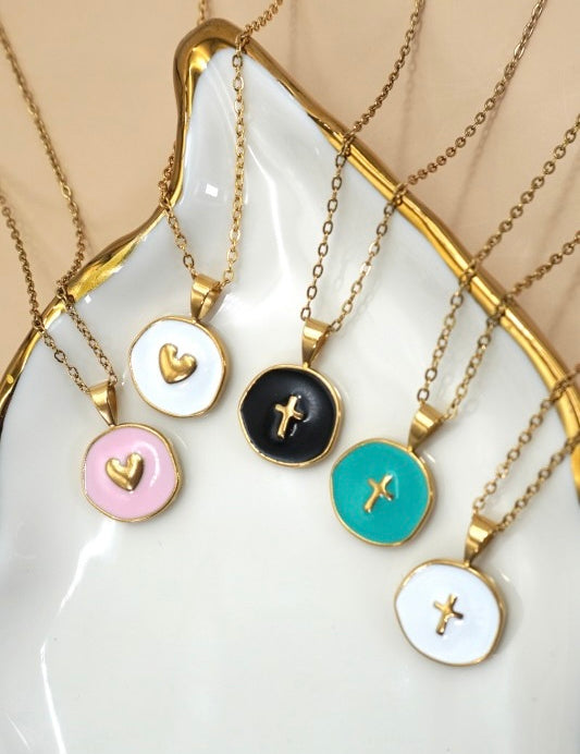 Set of necklaces with various pendants on a white dish