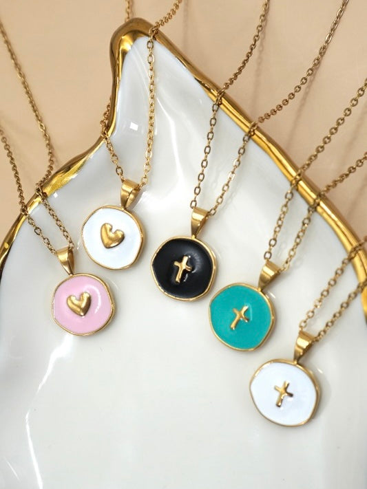 Set of necklaces with various pendants on a white dish