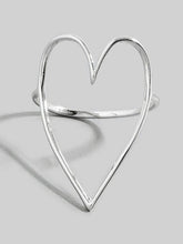 Silver heart-shaped ring on a light gray background