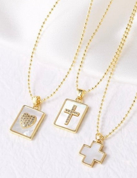 Three gold necklaces with pendant charms on a white background