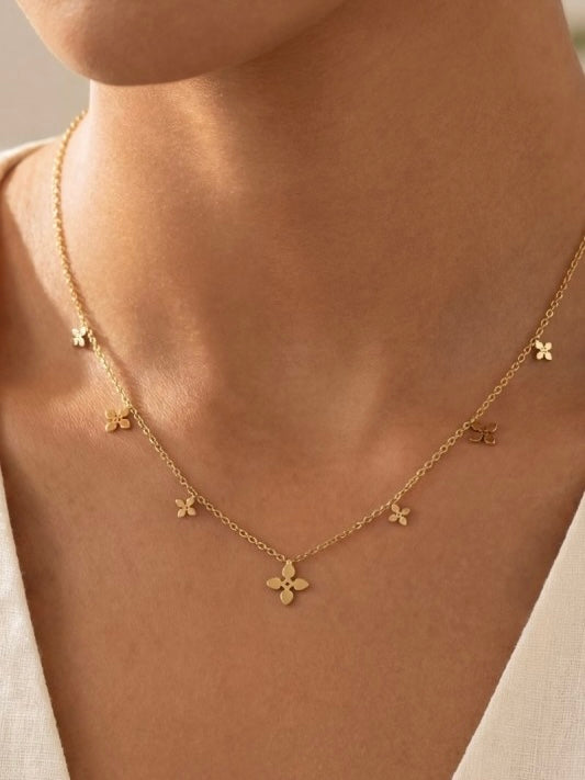 Gold necklace with floral pendants on a person's neck