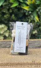 Ewe Creek Farm Co. Goldmember car diffuser with packaging on a wooden surface.