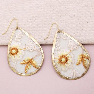 Teardrop-shaped earrings with gold accents on a pink background
