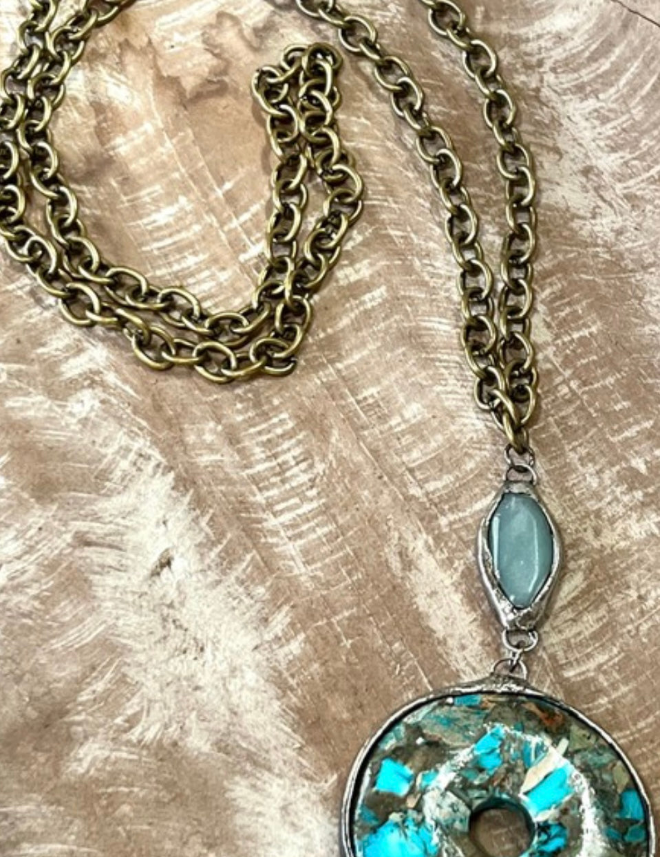 Necklace with a turquoise pendant on a textured surface