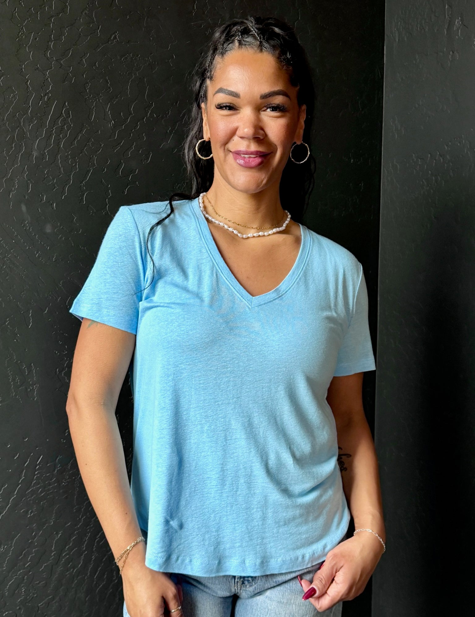 Woman wearing a light blue t-shirt against a black background