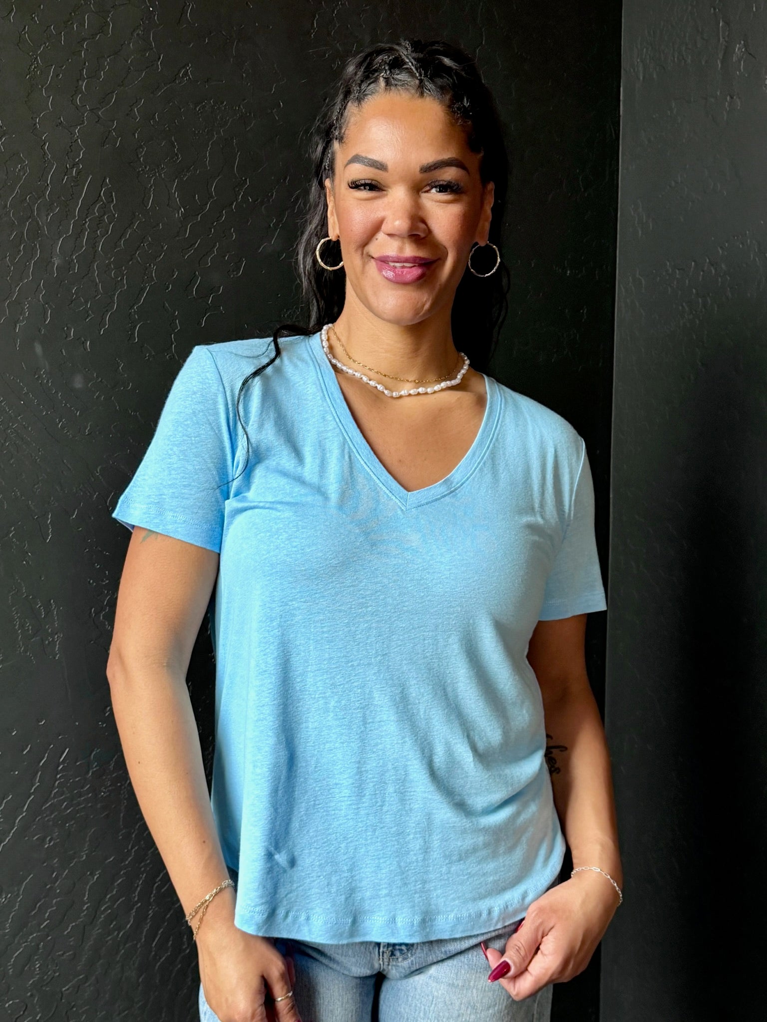 Woman wearing a light blue t-shirt against a black background