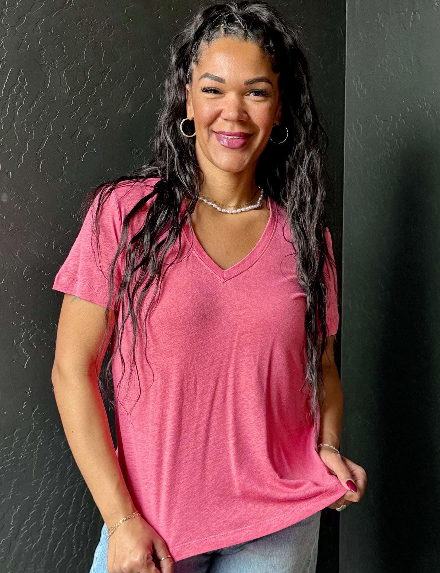 Woman wearing a pink shirt against a black background