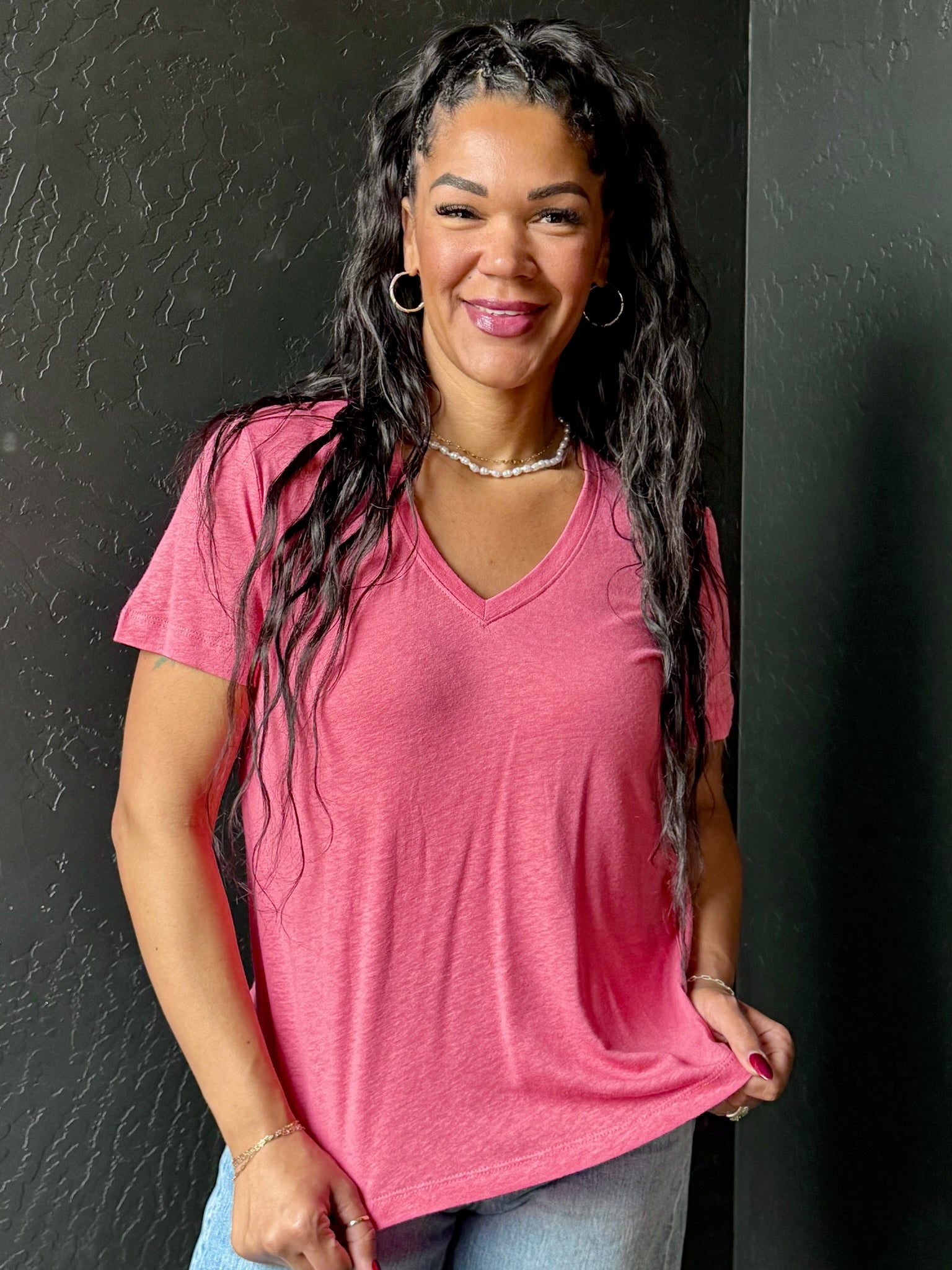 Woman wearing a pink shirt against a black background