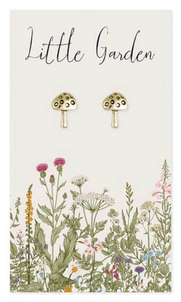 Mushroom-shaped earrings on a card with floral illustrations and 'Little Garden' text.