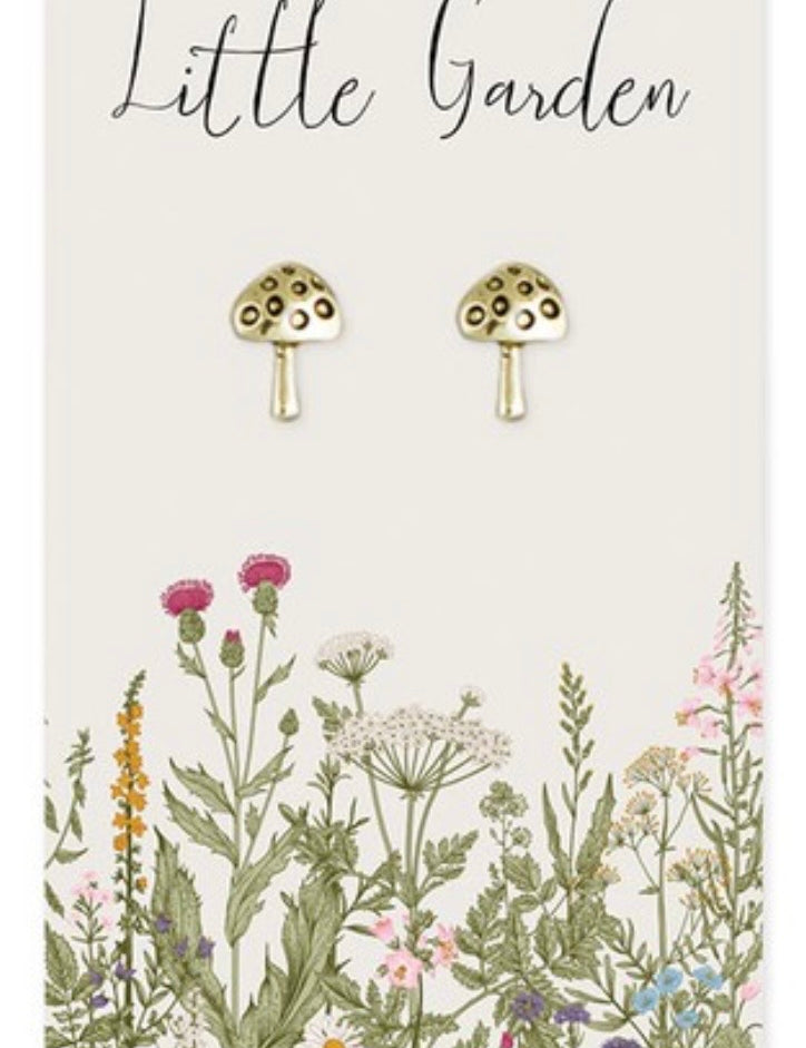 Mushroom-shaped earrings on a card with floral illustrations and 'Little Garden' text.