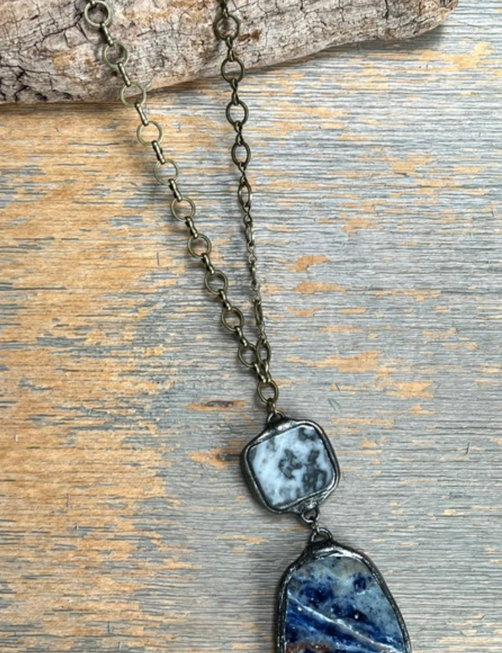 Necklace with two stone pendants on a wooden surface