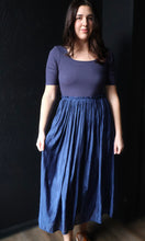 Woman wearing a blue dress against a dark background