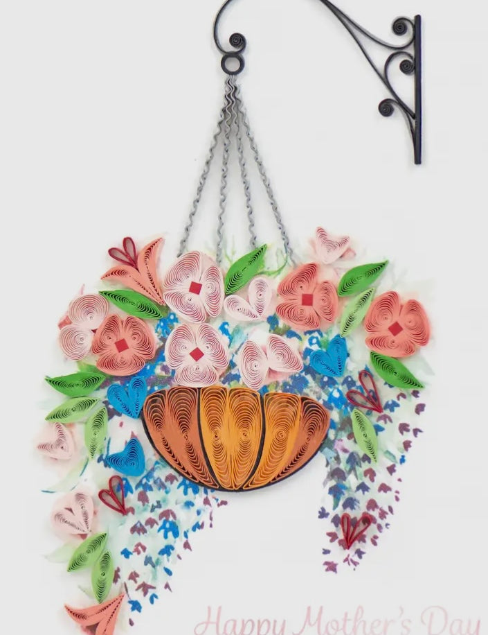 Decorative hanging basket with flowers and a heart on a white background, featuring 'Happy Mother's Day' text.