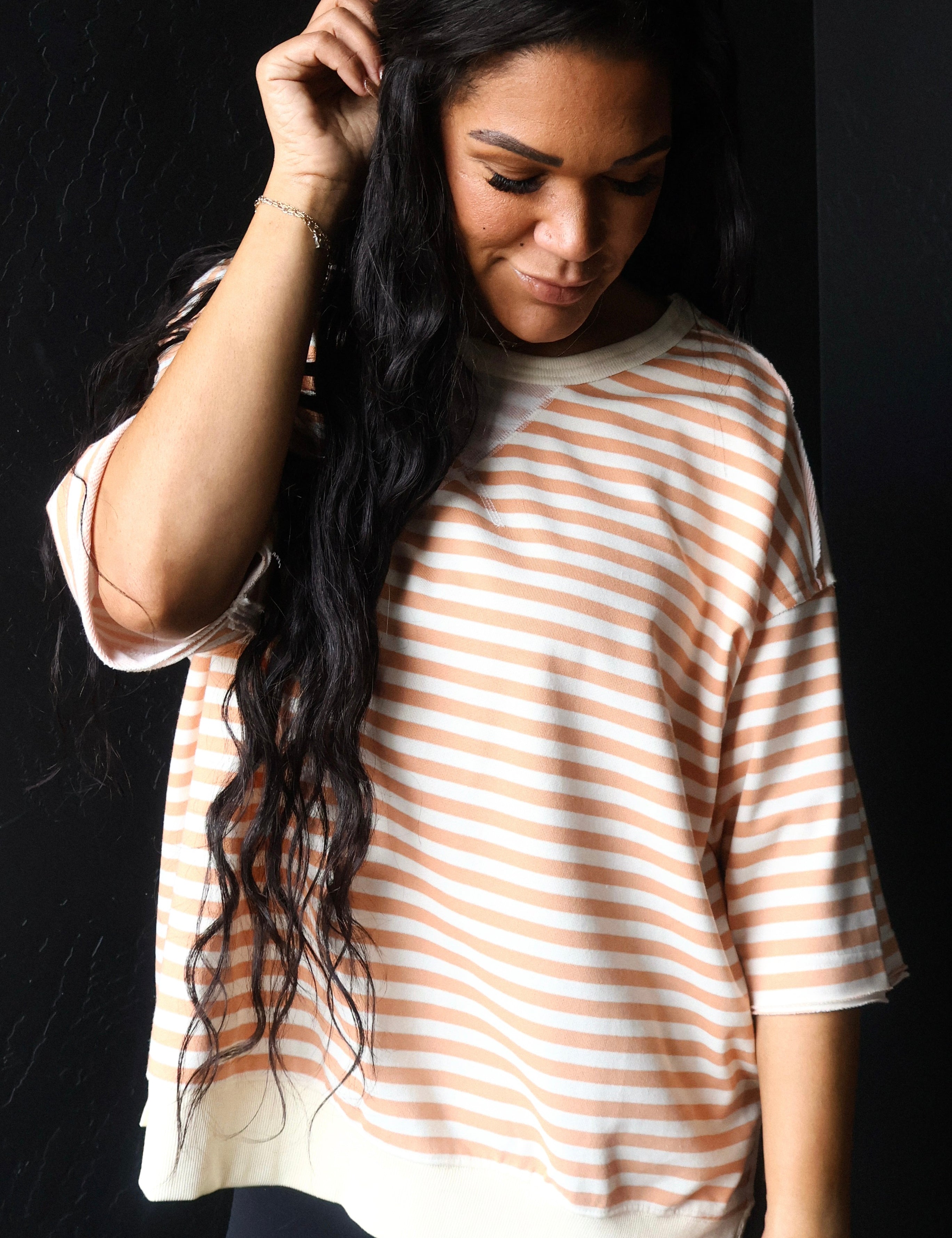 Woman wearing a striped shirt against a black background