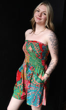 Woman wearing a colorful strapless dress against a black background