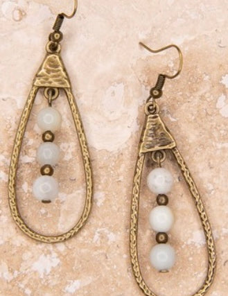 A pair of bronze teardrop-shaped dangle earrings with amazonite beads, displayed against a textured background.