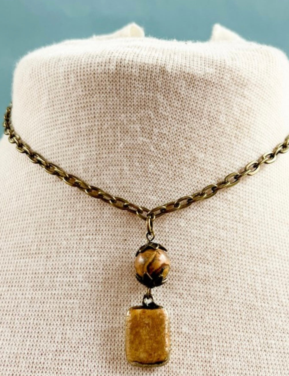 Necklace with a pendant on a mannequin bust against a light background