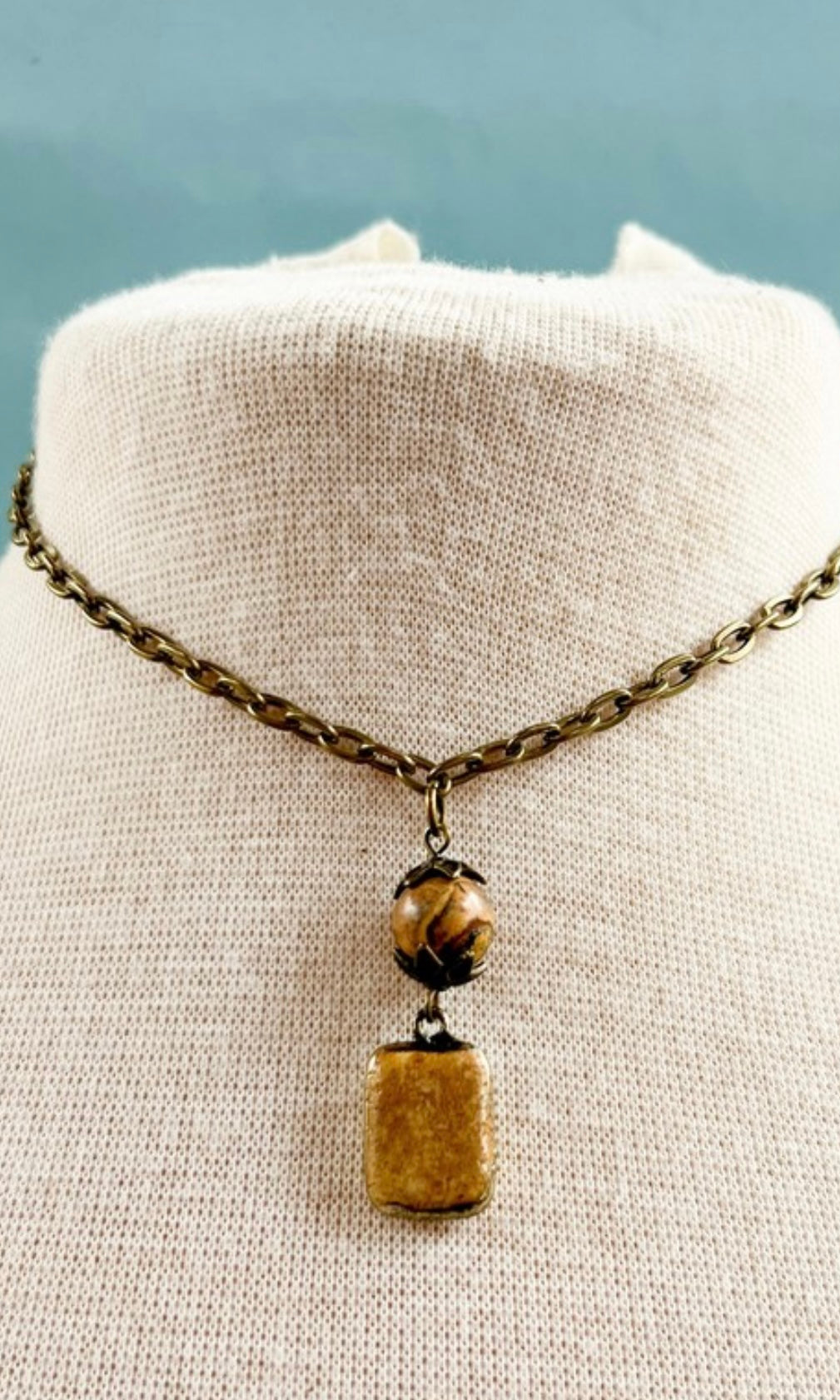 Necklace with a pendant on a mannequin bust against a light background