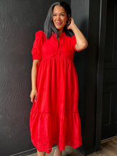 Woman wearing a red dress against a black wall